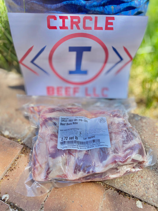 Packaged beef ribs with a 'Circle I Beef LLC' label on a stone surface.